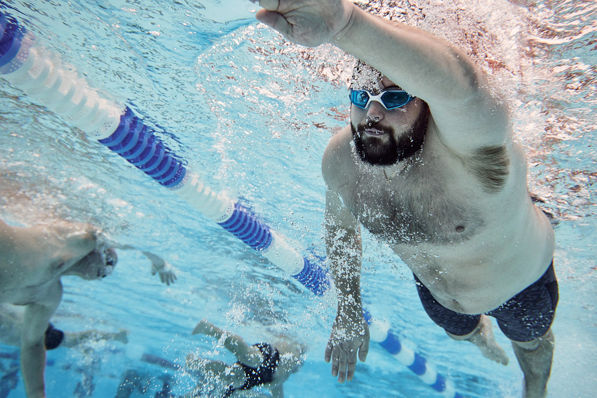 Man swimming frontcrawl, photographed from beneath under the water.