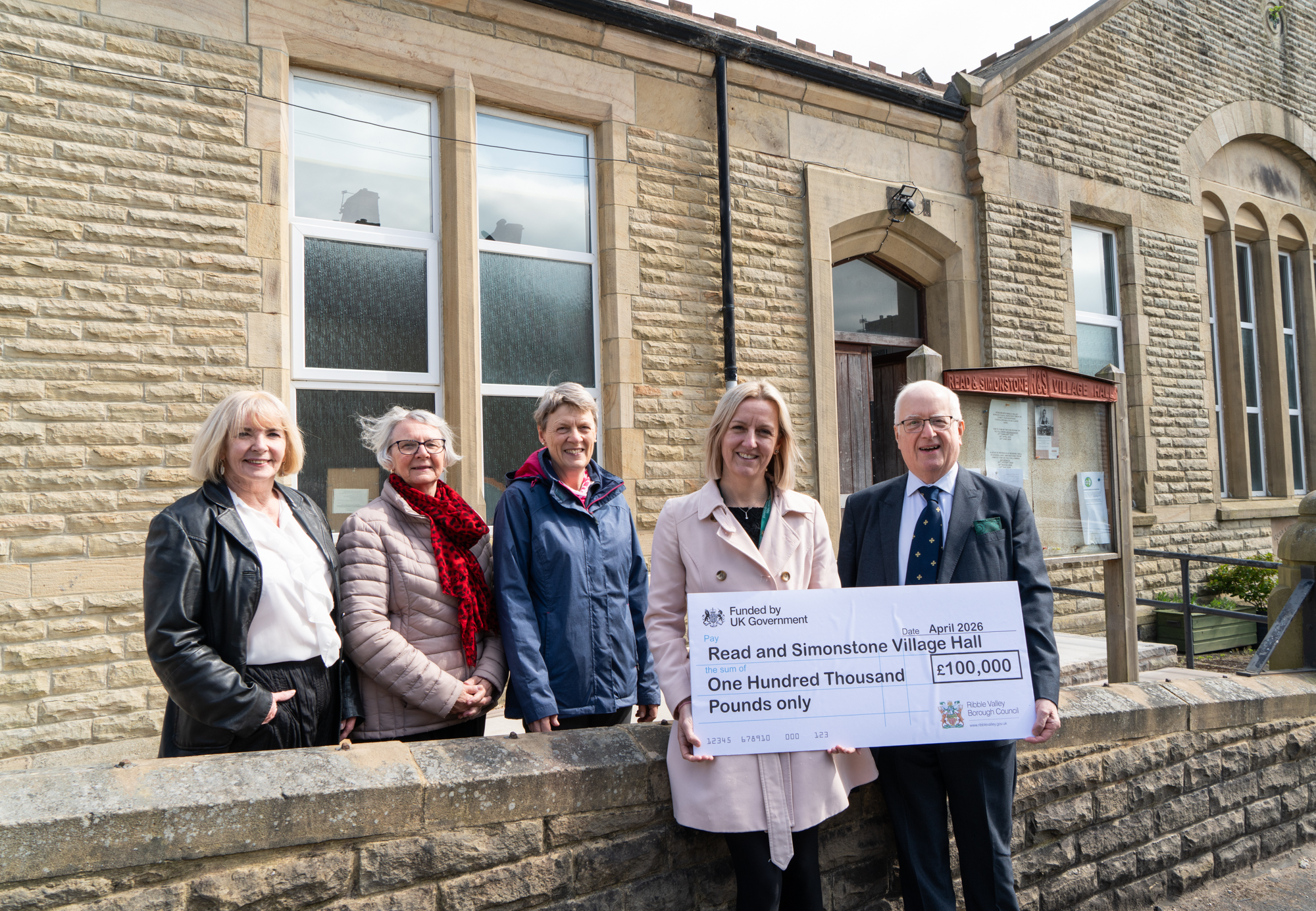 RVBC director of economic development and planning stood with an oversized cheque and 4 trustees, outside Read and Simonstone village hall.