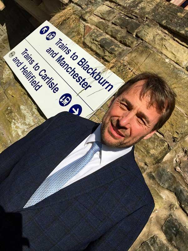 Stephen Atkinson stood near Clitheroe to Hellifield sign.