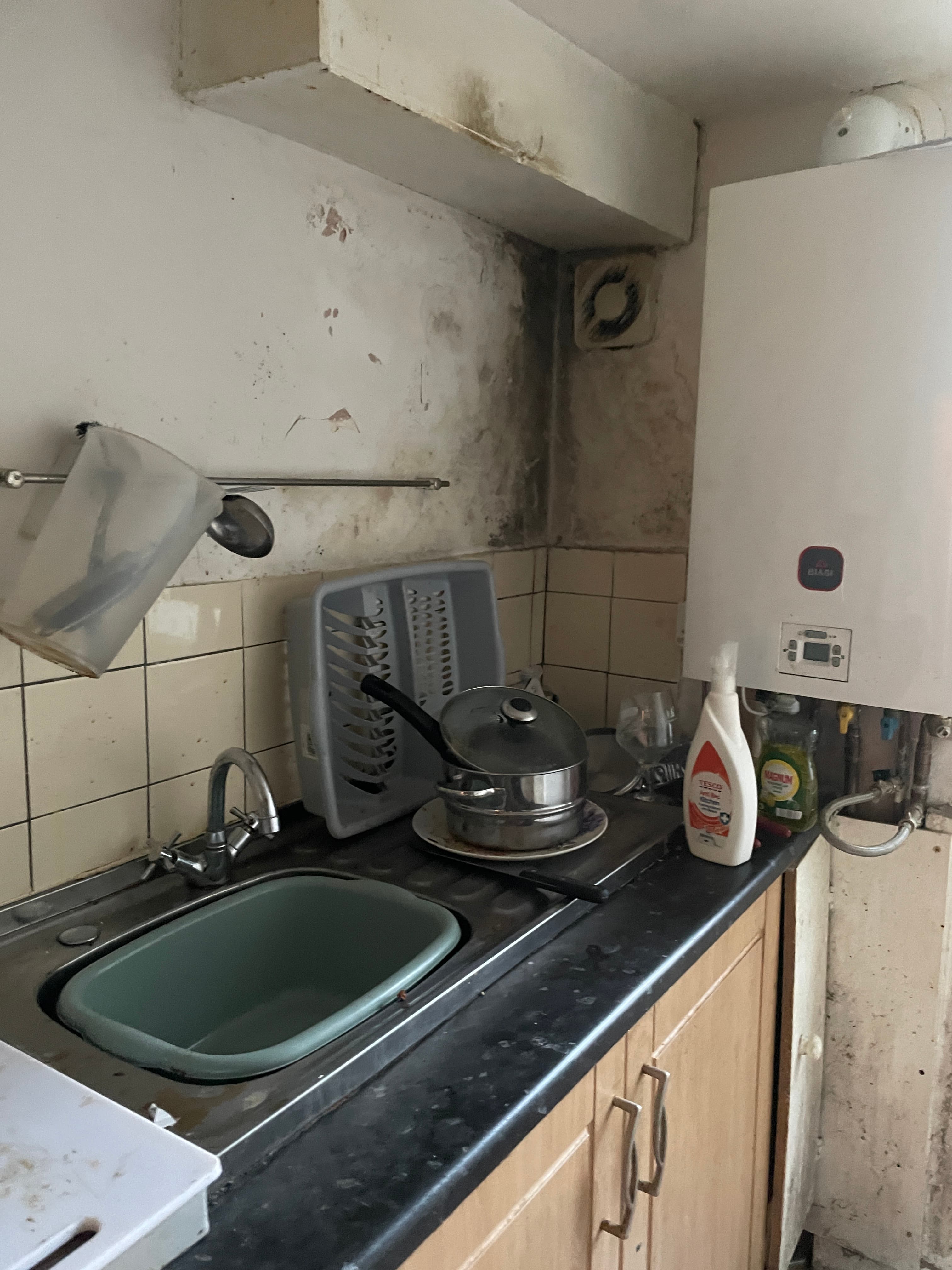 A small kitchen with several areas of damp,