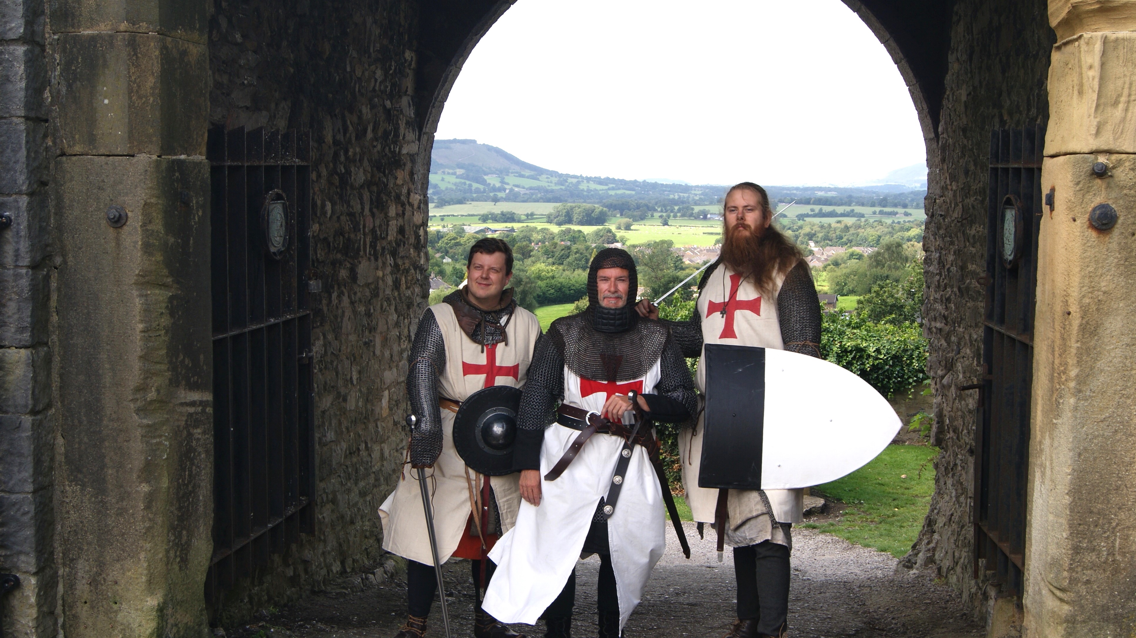 3 men dressed as knights stood in an archway at Clitheroe Castle