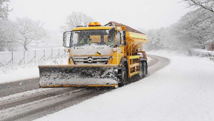 Gritter with plough clearing the road