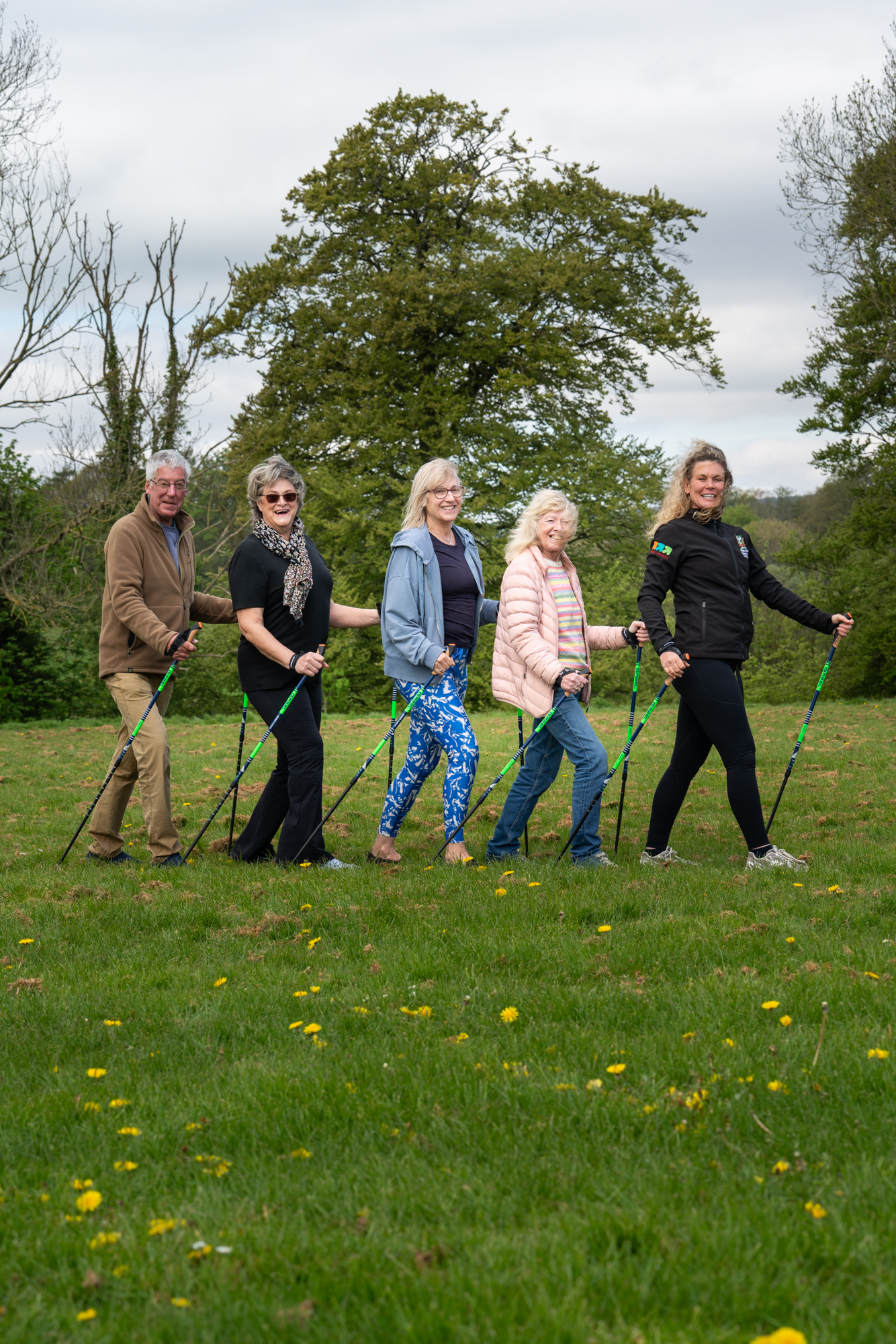 Five people stood in a row holding walking poles.